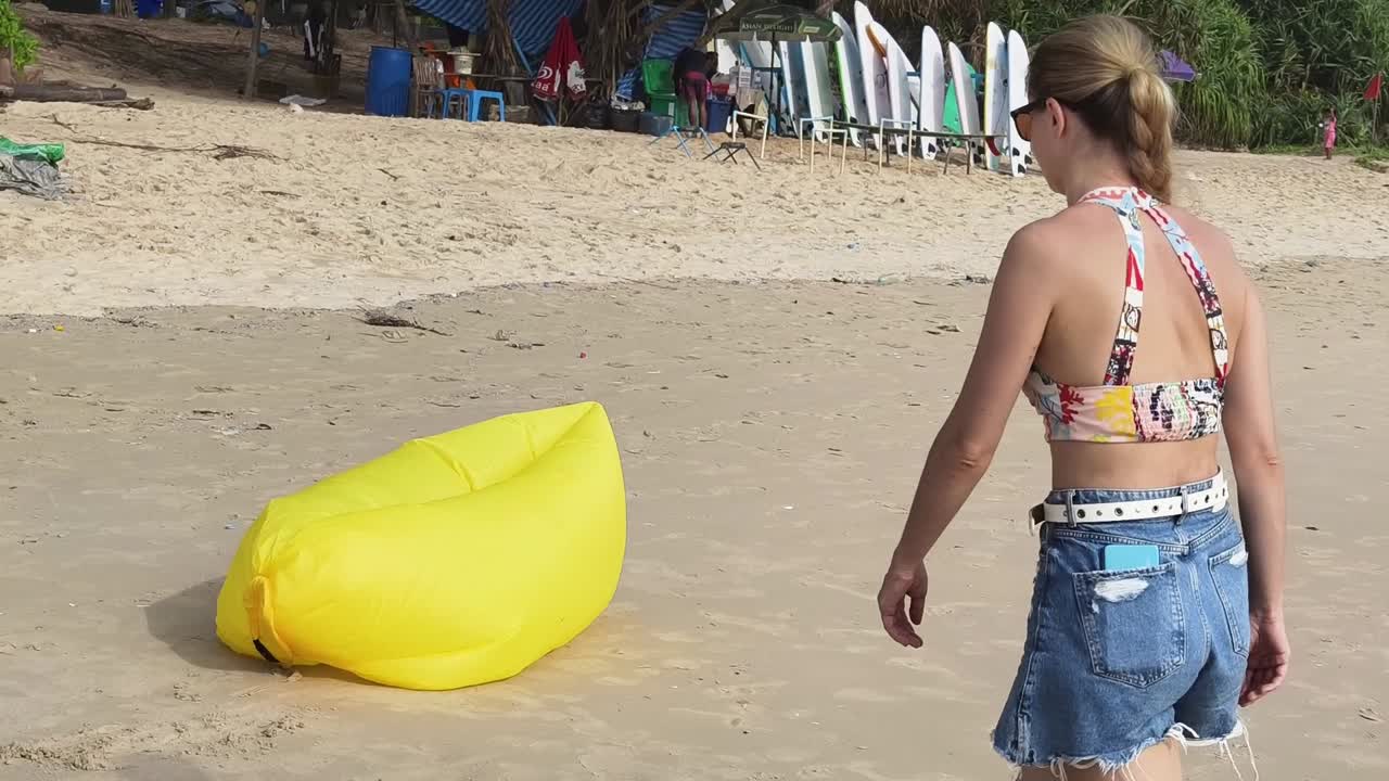 mujer relajándose en la playa con una tumbona inflable