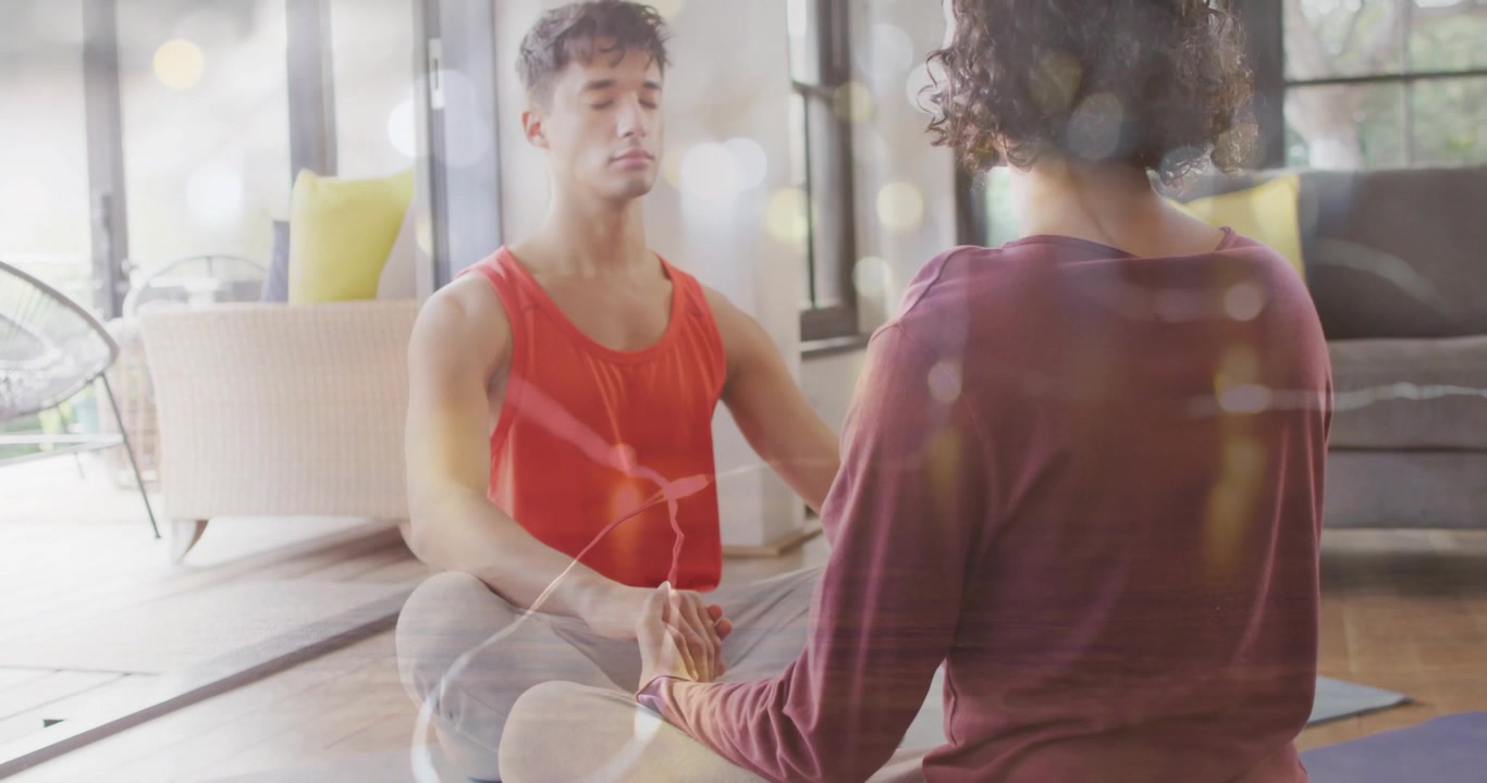 To voksne sidder i stuen, begynder at folde håndfladerne, trækker vejret og praktiserer meditation.