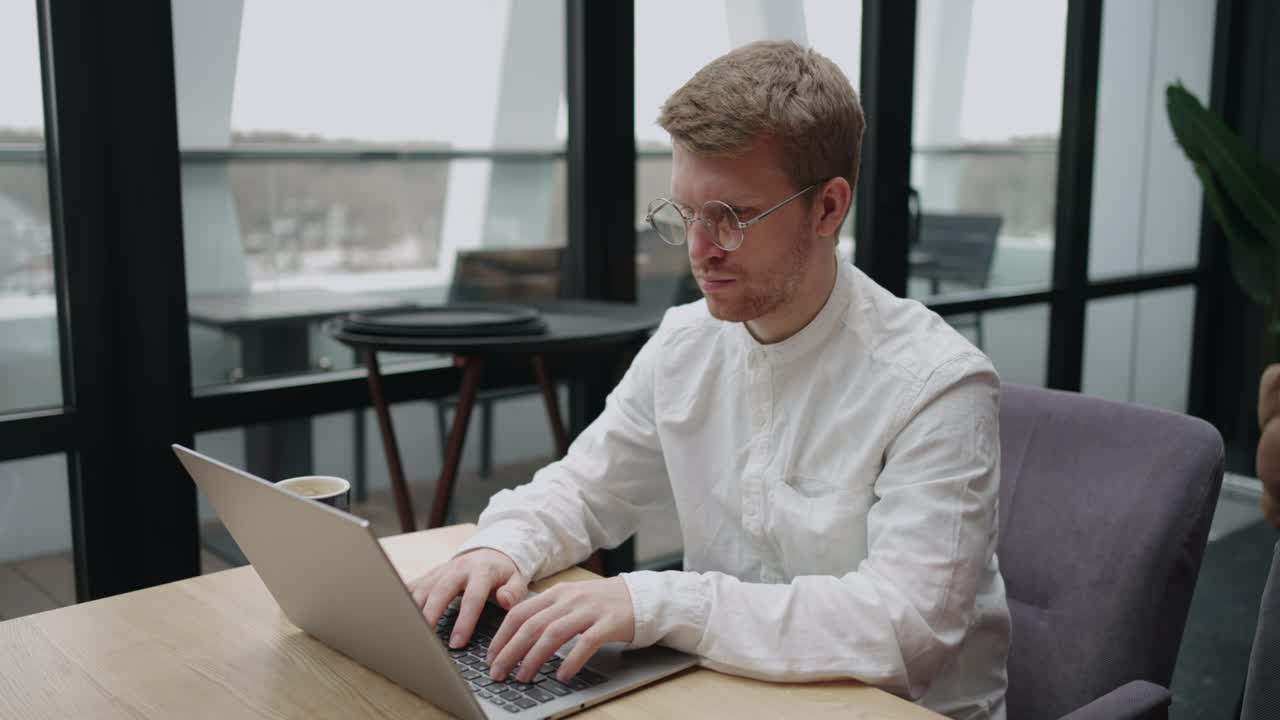 freelancer man is working with laptop in cafe, using wireless internet and wifi, sending message by email