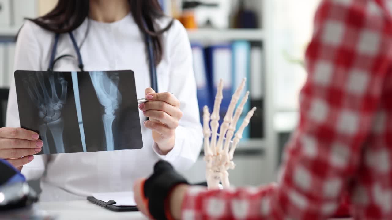 Surgeon carefully looks at xray of wrist and make diagnosis