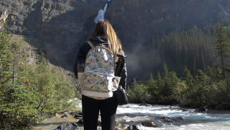 girl watching a gigantic waterfall  from up close