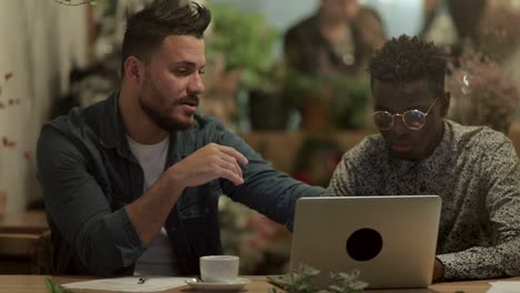 multiracial freelancers working together in cafe