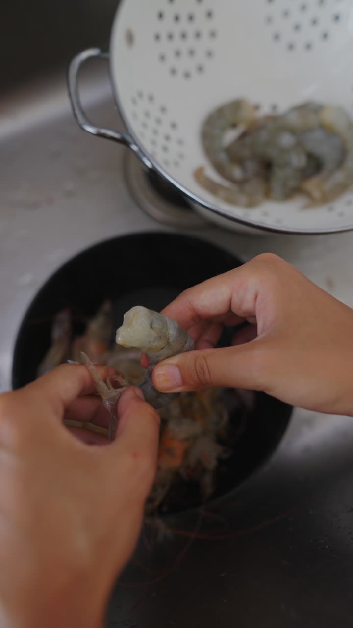 Person Peeling Raw Shrimp in a Kitchen Sink