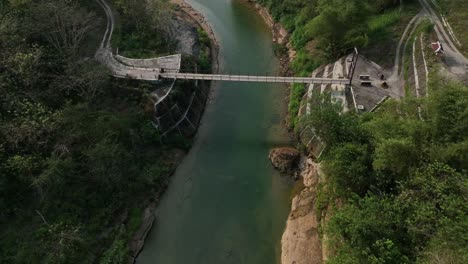 drone passing over river oyo and the gantung wanagama bridge at the start of the dry season - with matching foliage