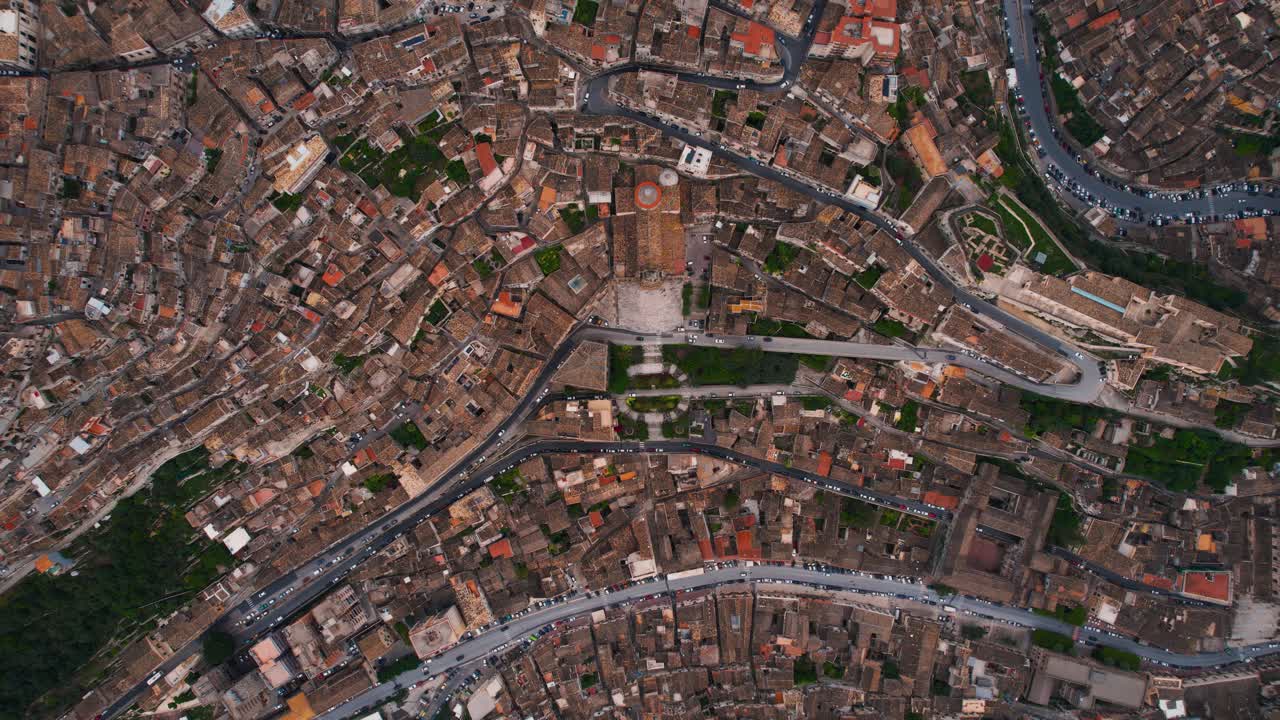Dramatic top-down view of San Giorgio Cathedral with winding roads of Modica old town. Sicily, Italy