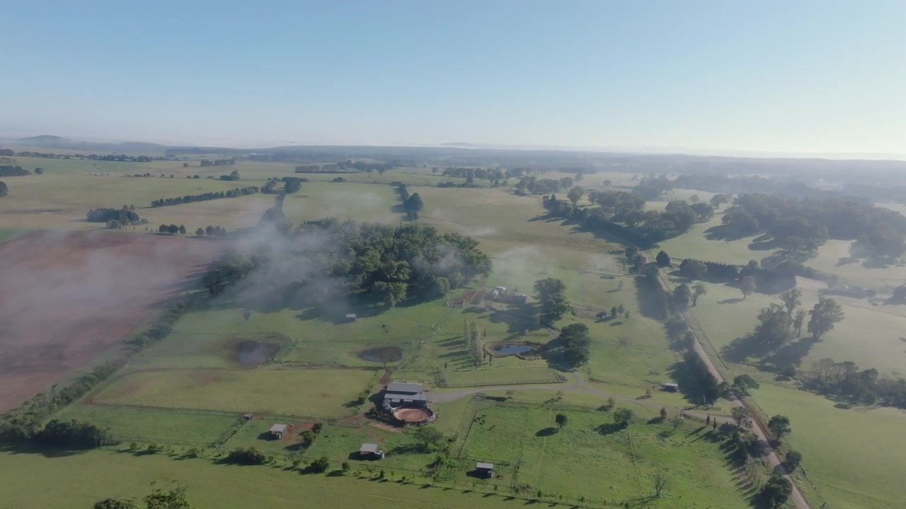 Vista aerea con drone su dolci terreni agricoli e proprietà rurali nelle Southern Highlands del Nuovo Galles del Sud, Australia