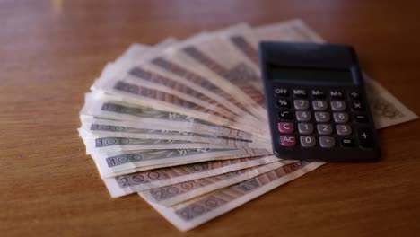 polish money lies with a calculator on the table, polish zloty counting money