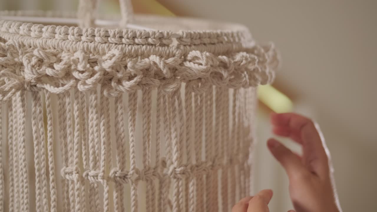 집에서 마크라메를 뜨개질하는 취미. 여성의 손은 두꺼운 가닥으로 장식을 뜨개진다.