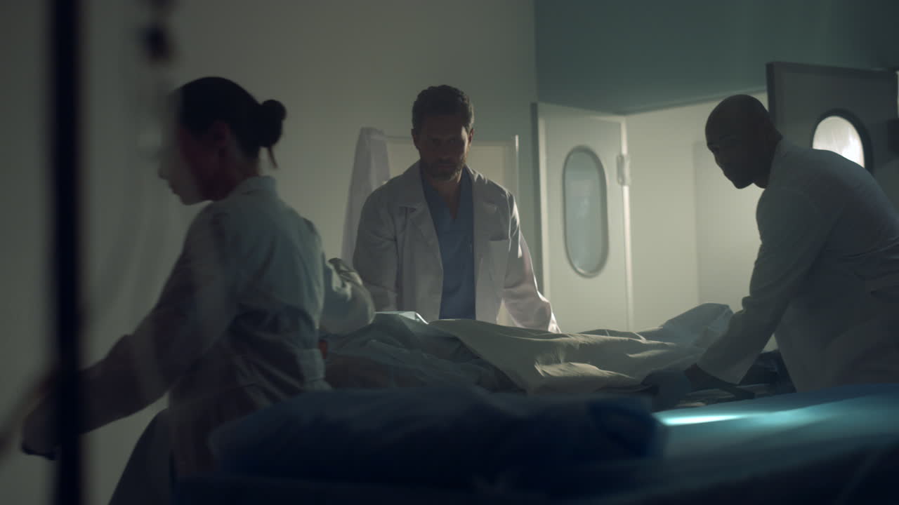의사 들 은 성공적 인 수술 치료 후 환자 를 어두운 병원 병동 으로 데려간다