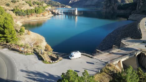 rv motorhome at water reservoir in sierra nevada, andalusia, spain - aerial 4k tilting up