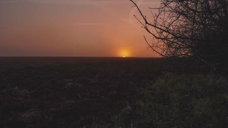 Zeitraffer-Einer-Goldenen-Sonne,-Die-Hinter-Dem-Horizont-Untergeht,-Dolly-Rein