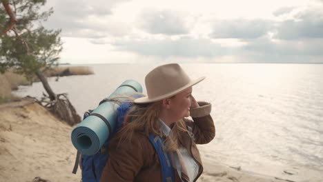 una atractiva mujer pelirroja con curvas caminando feliz junto a un lago