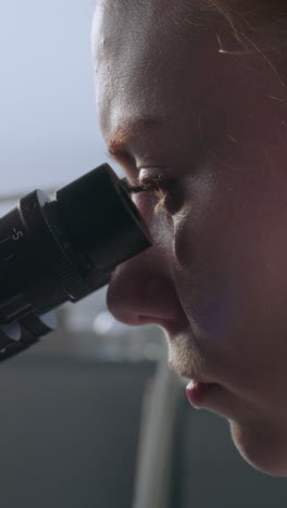 scientist looking through a microscope