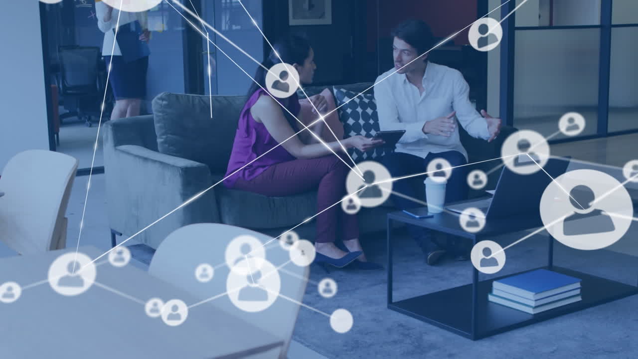 Animation of network of profile icons against diverse man and woman discussing at office