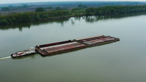 Schlepper,-Der-Lastkähne-Auf-Der-Donau-Schiebt,-Vorbei-An-Der-Stadt-Vukovar,-Kroatien