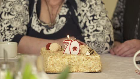 ancianos en la celebración del 70 aniversario. pastel con vela encendida número 70.