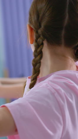 primer plano de chicas jóvenes en una sesión de entrenamiento sosteniendo globos mientras se estiran, expresiones enfocadas, entorno de gimnasio con equipos de fitness en el fondo