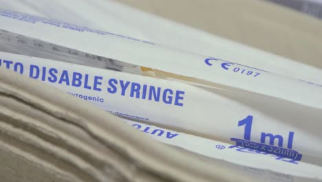 disposable plastic syringe, medical preparations in background