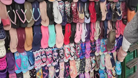 video of a market stand rack with many types of women's sandals for sale