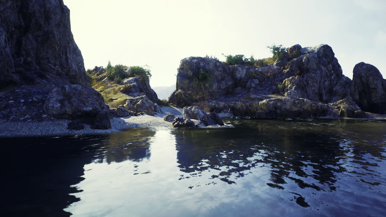 Rocky shoreline at a tranquil lake during golden hour provides serene escape