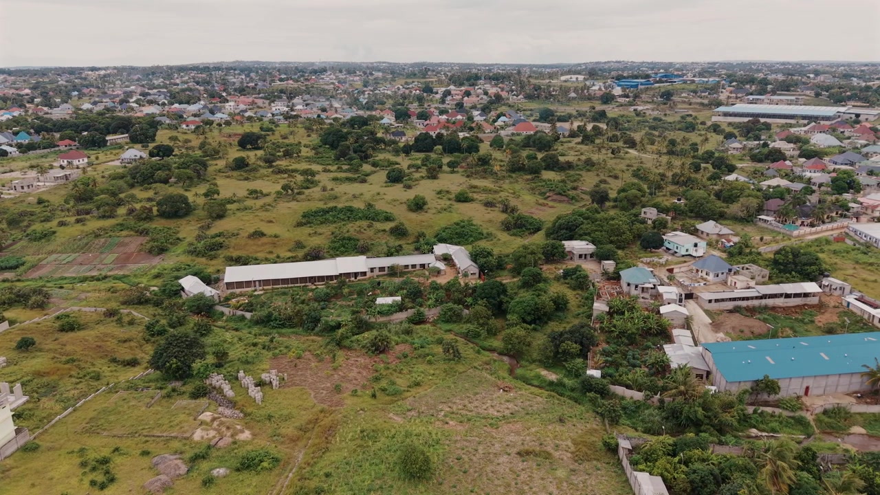 Vista aerea di Kibada–Kigamboni a Dar es Salaam che mostra modelli di insediamento rurale, sviluppo abitativo e architettura umana.