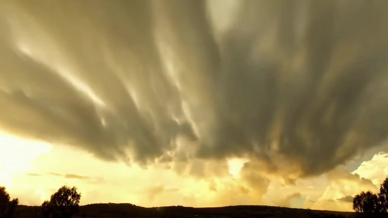Time-lapse drammatico di nuvole che si muovono attraverso un cielo dorato al tramonto