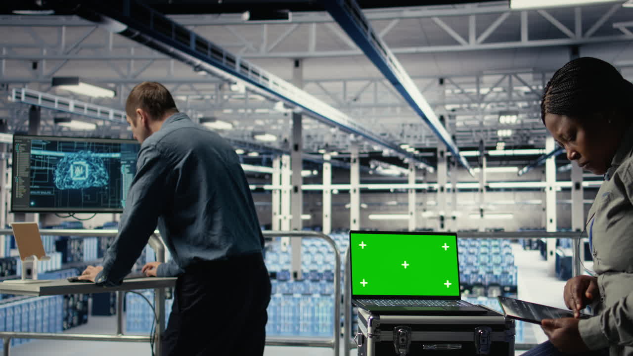 Data Center Technician Monitors Deep Learning Process With Green Screen Laptop