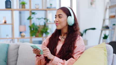 headphones, cellphone and woman dancing on a sofa