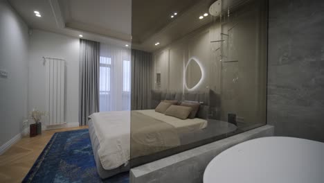dormitorio de lujo con un cabecera de tuft y baño integrado con una bañera independiente y espejo iluminado