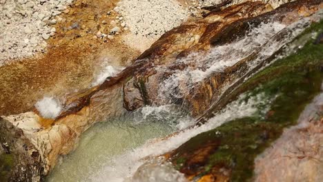 Entspannender-Wasserfall-Im-Orangefarbenen-Felsen,-Aufnahme-Von-Oben,-60-Fps