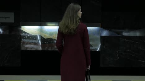 mujer esperando en una estación de metro