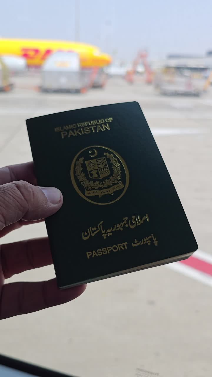 Pakistani passport at airport with DHL airplane in background
