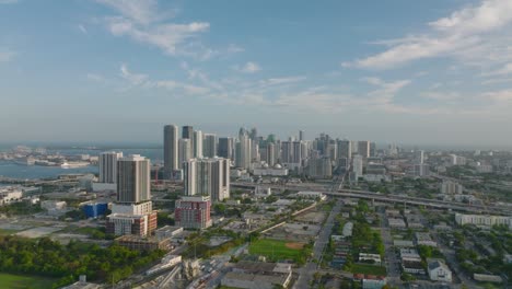 slide and pan aerial shot of high rise buildings in modern urban borough. golden hour in city. miami, usa