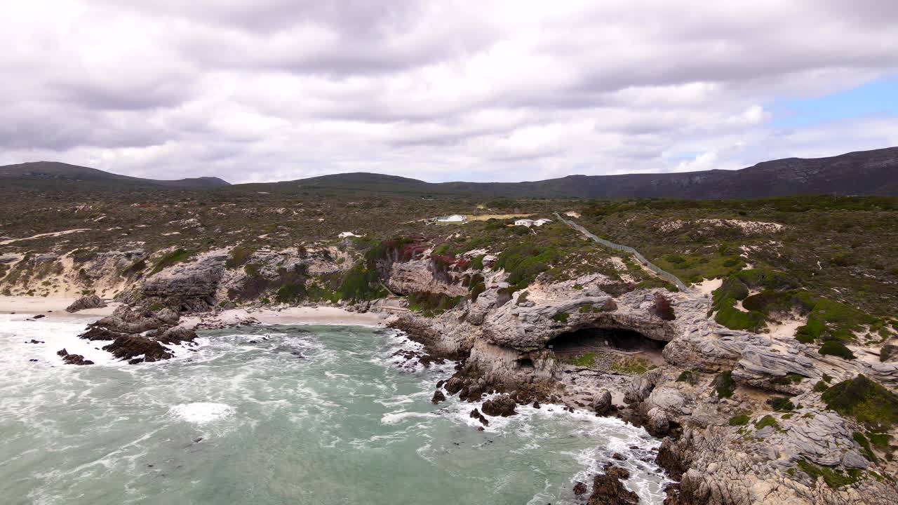 Limestone coastal cliff with historic Klipgat Cave in Walker Bay reserve, drone