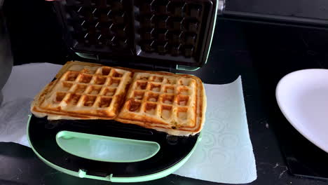 opening an electric waffle maker with hot belgian waffles cooked inside - close up, slow motion