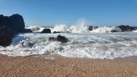 Powerful-waves-crash-against-the-rocky-shoreline-in-Crimea,-showcasing-the-natural-beauty-of-the-Sea-of-Azov-on-a-clear-day