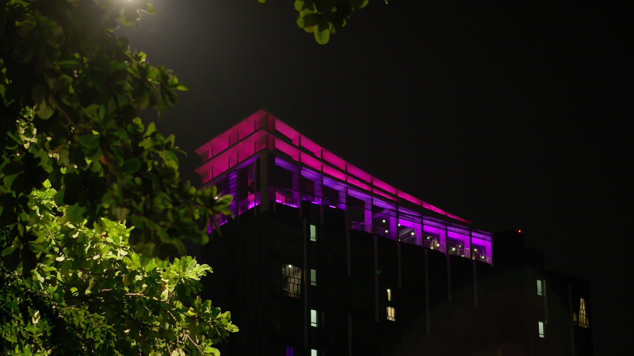 Modern Building with Changing Colorful Facade Lights at Night