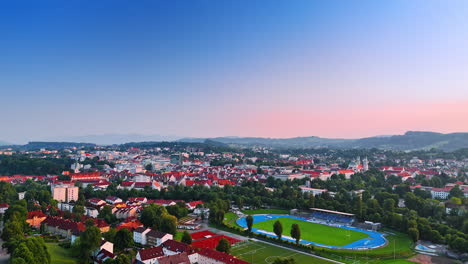 rising over the cozy town with bright houses. large stadiums are in the center. germany. aerial view