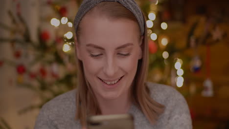 Young-Woman-Browsing-Internet-On-Smartphone-At-Home