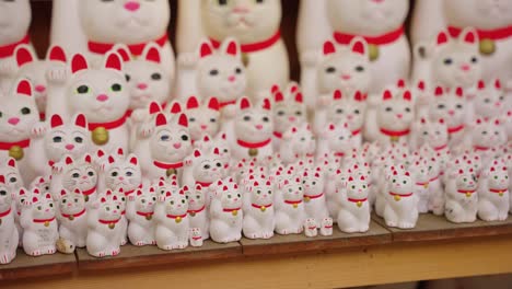 Maneki-Neko-„Glückskatzen“-Im-Gotokuji-Tempel-In-Tokio,-Nahaufnahme-über-Puppen-4K