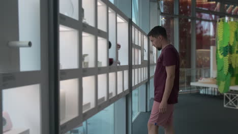 hombre viendo una exposición de diseño moderno en un museo