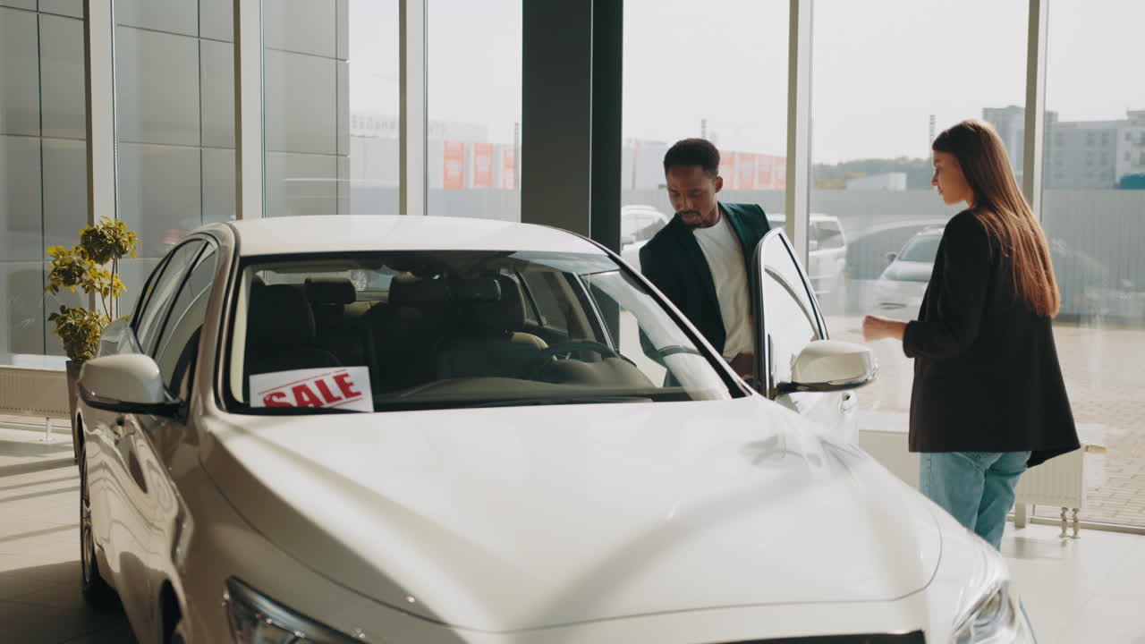 pareja mirando un coche nuevo para la venta en un concesionario de automóviles