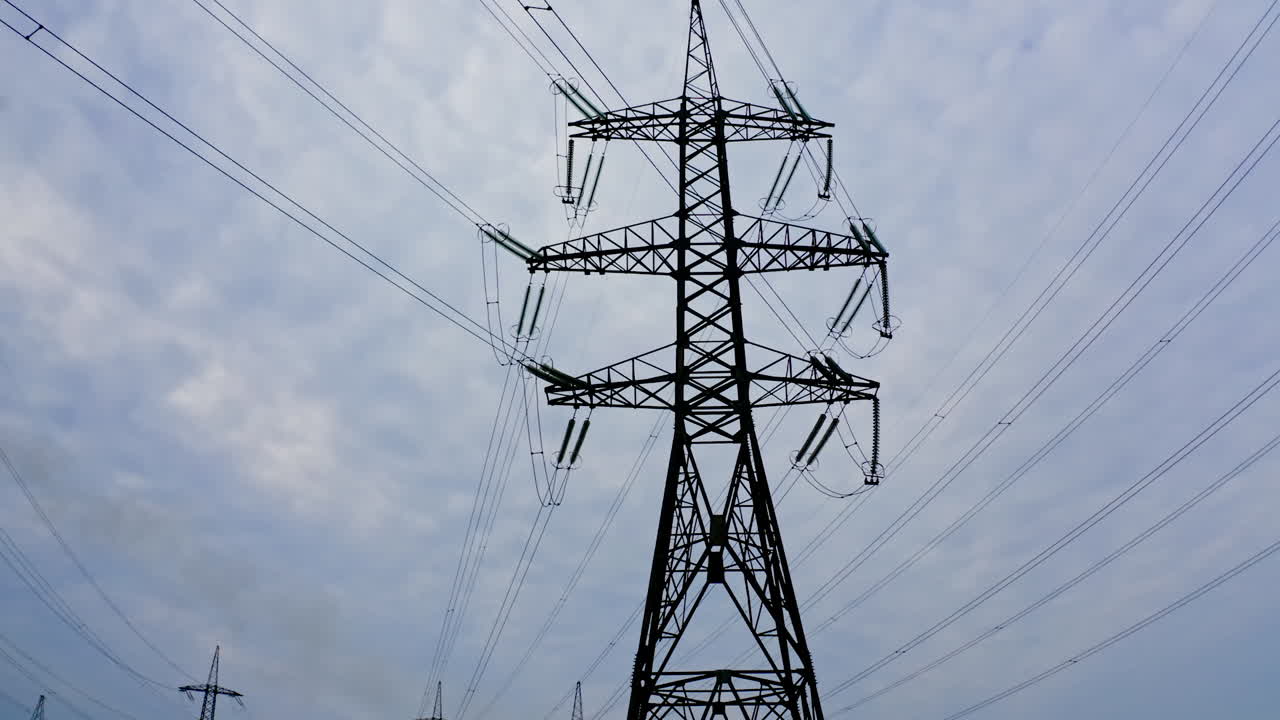 Energy distribution network. Electricity pylons against orange and yellow sunset. Selective focus.