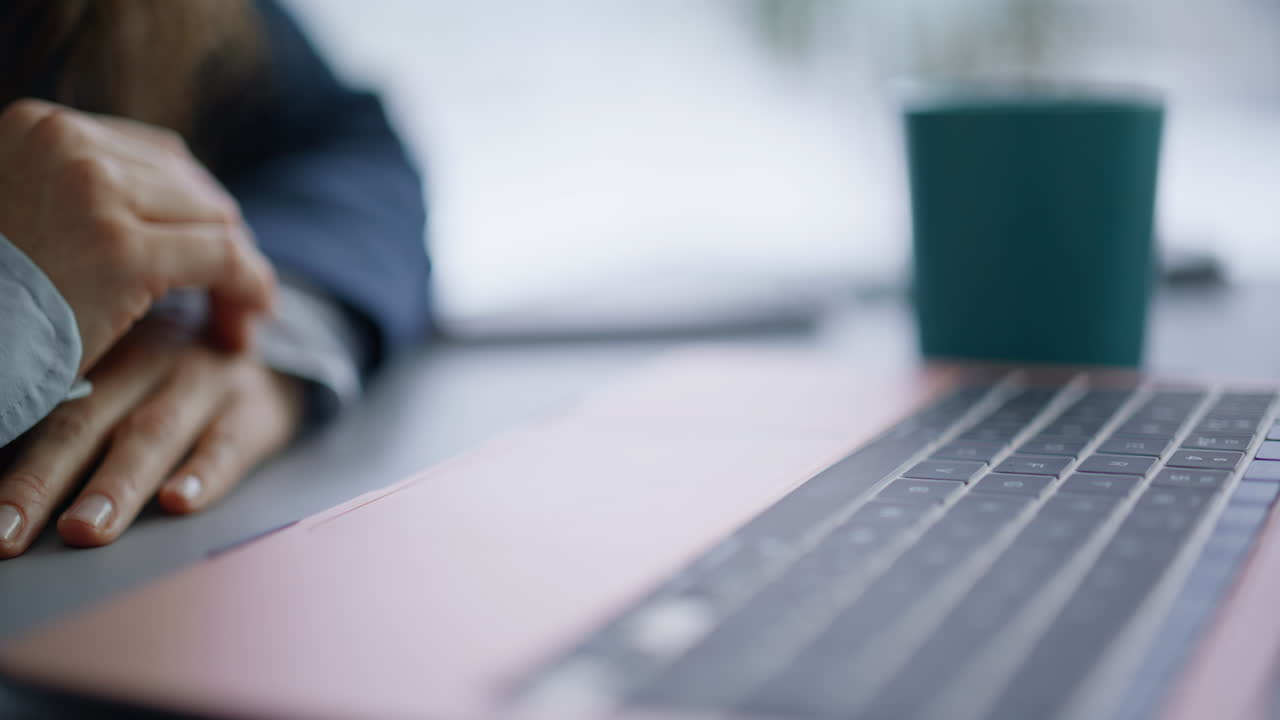 Sormi koskettaa kannettavaa tietokonetta surffaten internetissä, lähikuva työpaikalta. Liikenainen työskentelee