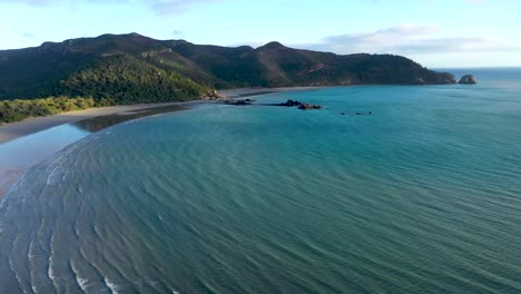 Cape-Hillsborough-aerial-tracking-backwards-with-turquoise-ocean-waves,-Mackay-Queensland