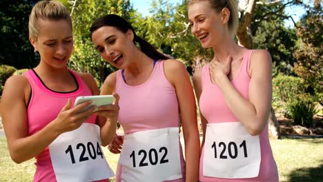 Young-female-athletes-looking-at-mobile-phone