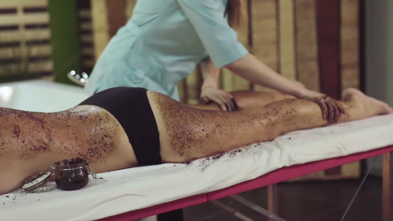 Woman receiving a coffee scrub body massage