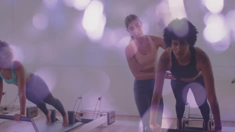 exercise class with women using reformer machines over bokeh lights animation