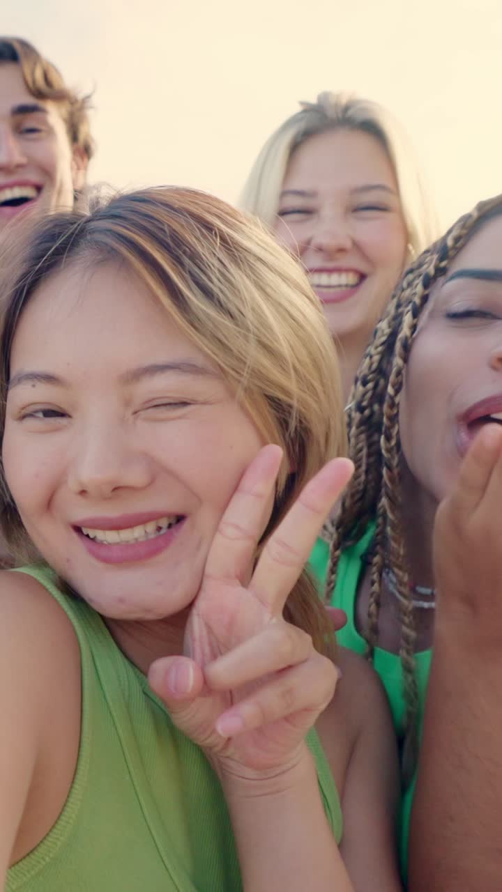 Chinese woman taking selfie with multi-ethnic friends outdoors
