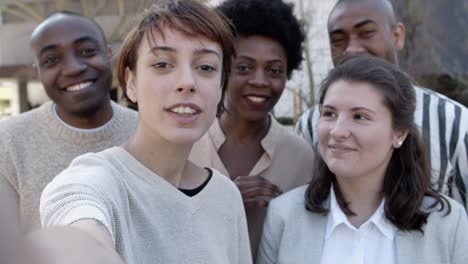 Group-of-young-people-talking-and-waving-to-camera